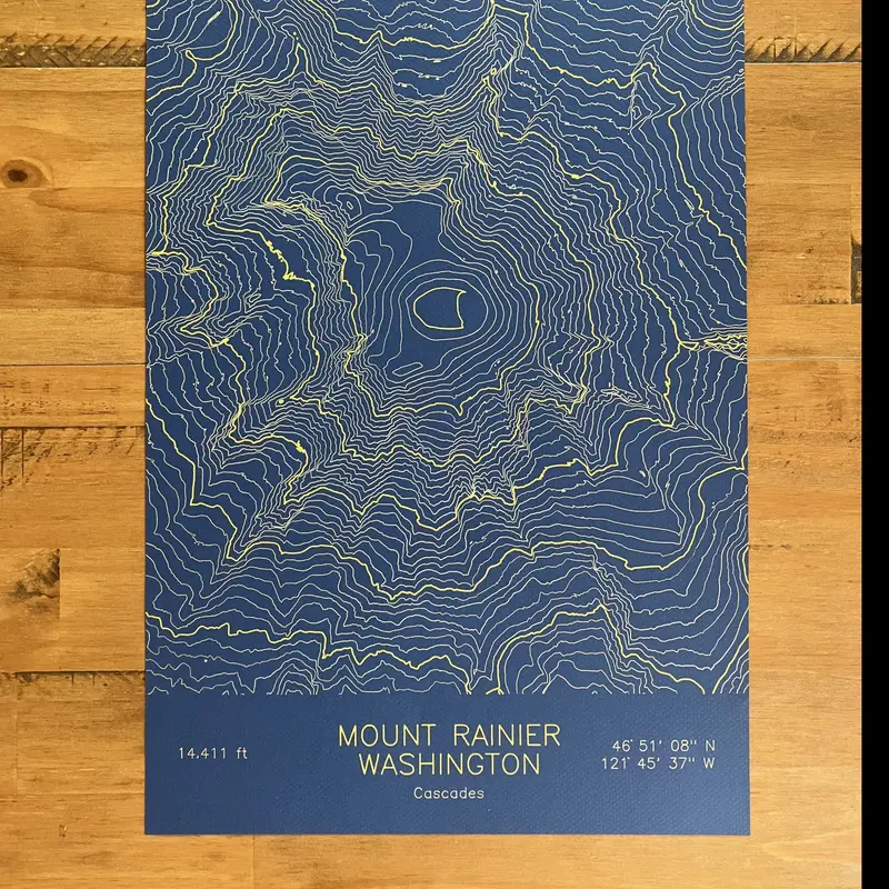 Framed pen-plotted topographic map in the navy colorway displayed in a real room, from the same series as this topographic map of Borah Peak, Idaho